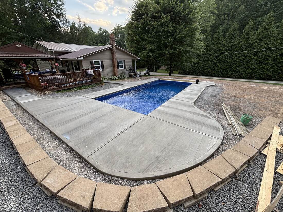 In-ground pool and concrete deck installation