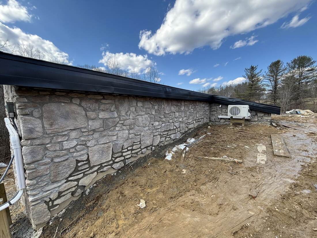 Natural stone veneer foundation wall